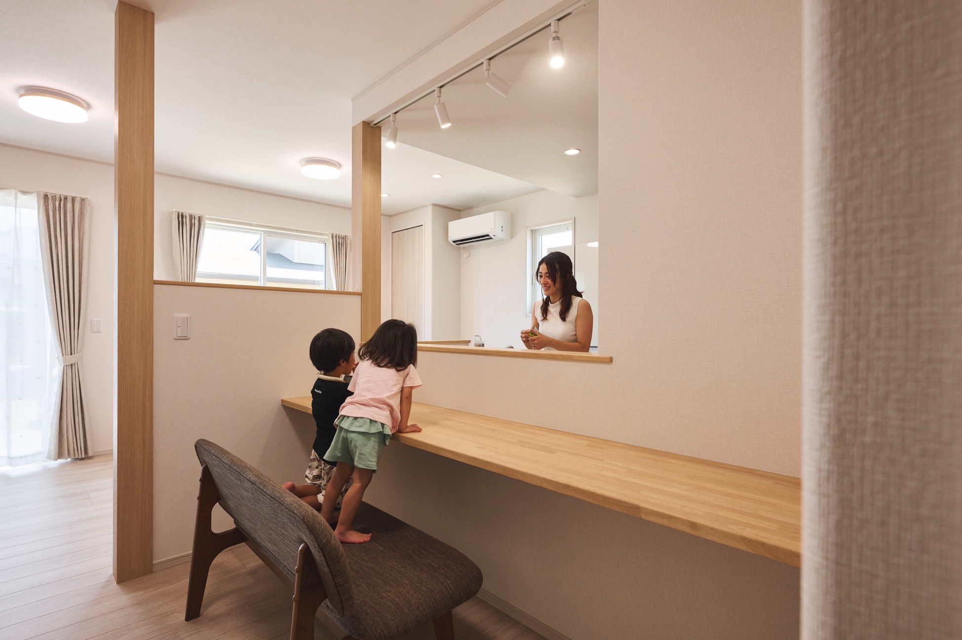 造作家具のカウンターで家事をしながら子供と会話をする様子